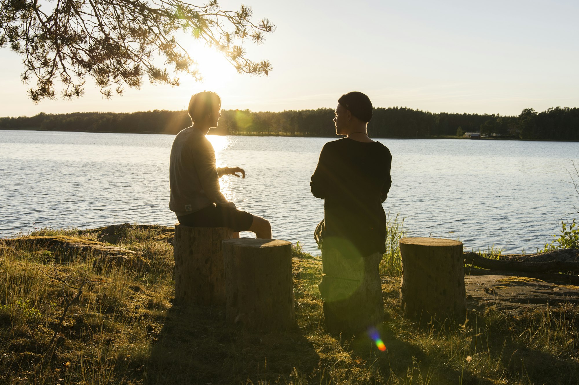 Deux personnes face à un lac au coucher du soleil